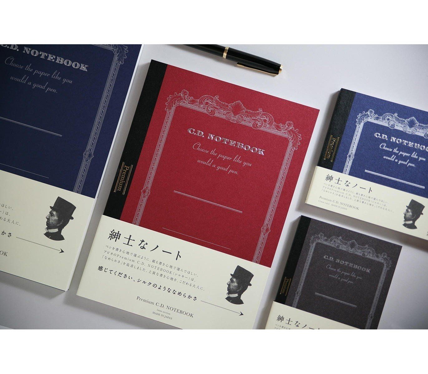 different notebooks in colors red blue with the japanese label with a gentleman in a hat